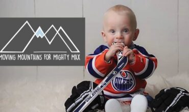 Garçon de deux ans tenant un bâton de hockey
