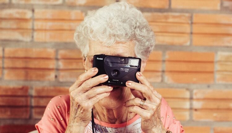 Une dame âgée tenant un appareil photo