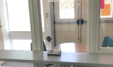 Une pièce séparée par une vitre et équipée d'un micro