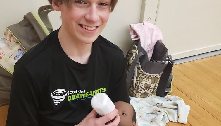 Un adolescent tenant un bébé-robot