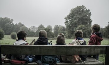 Cinq enfants assis sur un banc