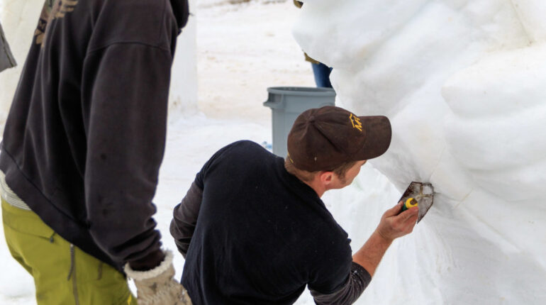 Deux hommes sculptant dans la neige