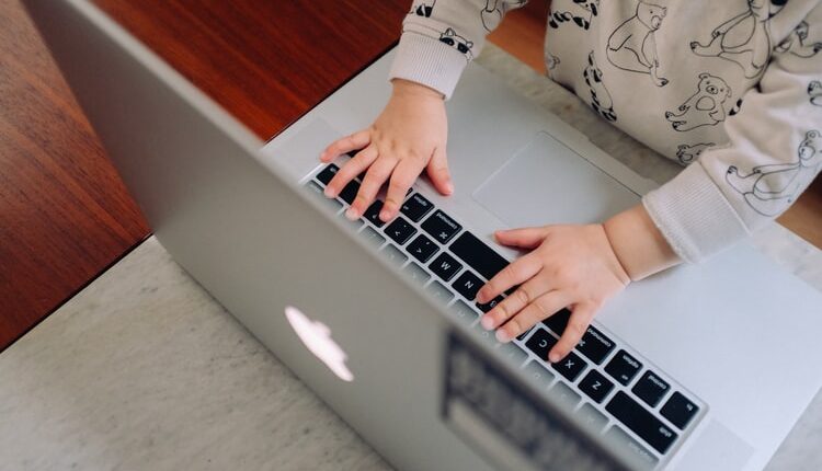 Enfant appuyant sur les touches d'un clavier de MacBook pro