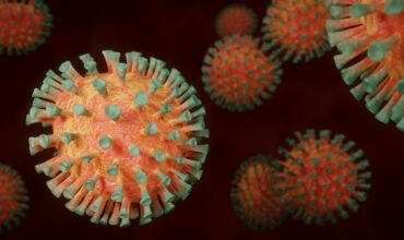 Coronavirus rond orange avec des minis trompettes vertes tout autour