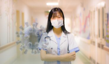 Femme docteure dans un corridor d'hôpital, portant un masque avec le signe du virus de la COVID-19,