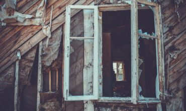 Une maison en bois avec une fenêtre calcinée.