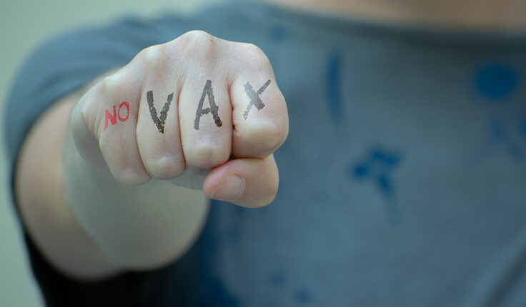 Un poing brandit avec l'inscription no VAX.